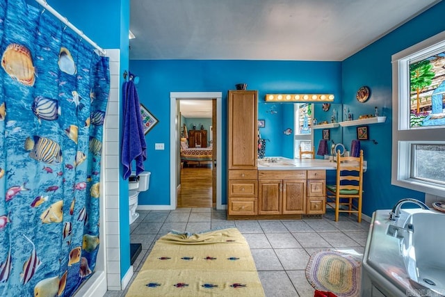 full bathroom with curtained shower, tile patterned flooring, vanity, and baseboards