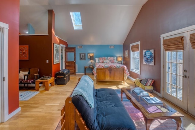 bedroom featuring high vaulted ceiling, a skylight, wood finished floors, and visible vents