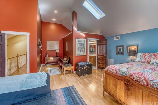 bedroom featuring lofted ceiling with skylight, visible vents, and light wood-style floors