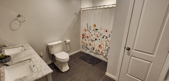 bathroom featuring toilet, tile patterned floors, baseboards, and vanity