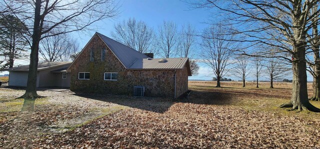 view of home's exterior with central air condition unit and stone siding