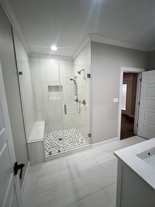 bathroom featuring ornamental molding, a stall shower, vanity, and baseboards