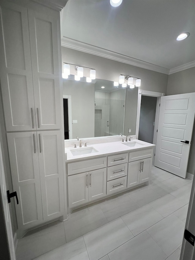 full bathroom with ornamental molding, a sink, a shower stall, and double vanity