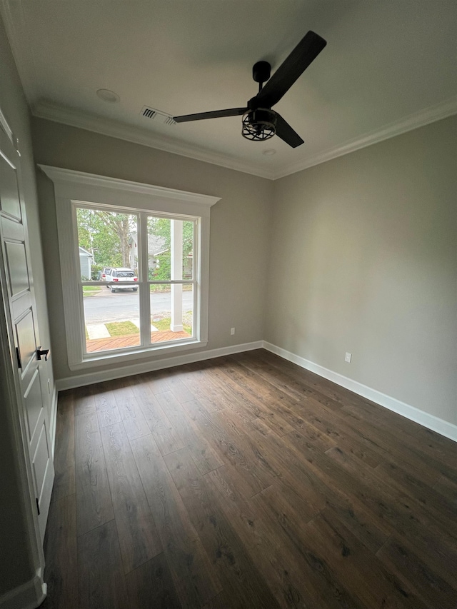 unfurnished room featuring dark wood-style floors, crown molding, visible vents, a ceiling fan, and baseboards