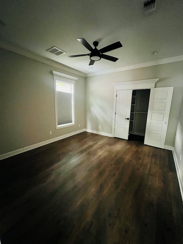 unfurnished bedroom featuring ornamental molding, baseboards, visible vents, and dark wood-type flooring