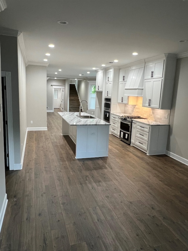 kitchen with custom range hood, appliances with stainless steel finishes, a sink, crown molding, and backsplash