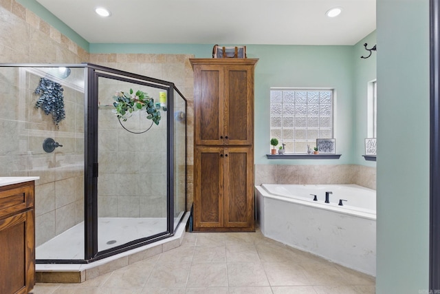 full bathroom with a stall shower, tile patterned flooring, a garden tub, and vanity