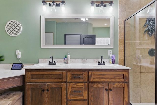 full bathroom with double vanity, a stall shower, and a sink