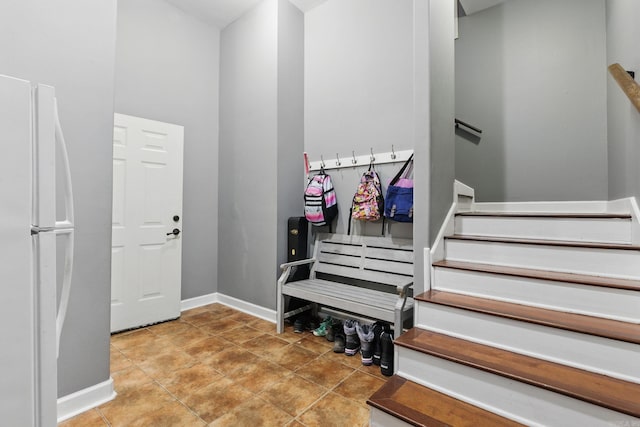 foyer entrance with baseboards, stairway, and tile patterned floors