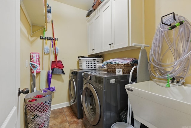 laundry room featuring cabinet space, a sink, tile patterned flooring, independent washer and dryer, and baseboards