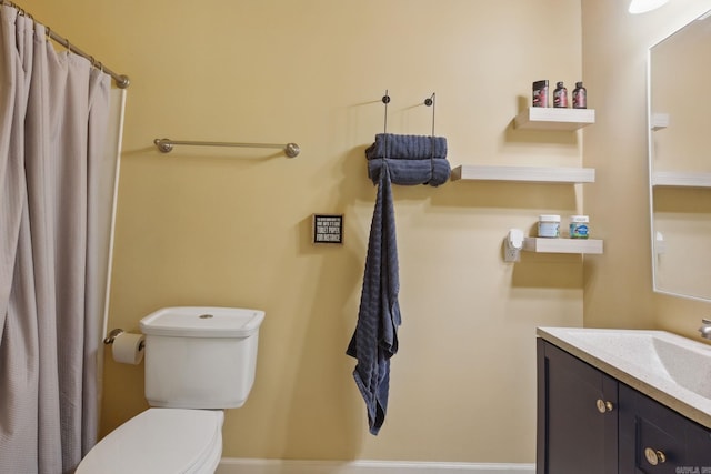 bathroom featuring toilet, curtained shower, and vanity