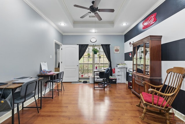 home office featuring ceiling fan, a tray ceiling, wood finished floors, and ornamental molding