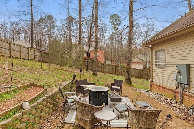 exterior space with an outdoor fire pit, a patio area, a fenced backyard, and a garden