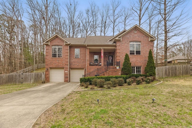 view of front facade featuring a garage, concrete driveway, a front yard, and fence