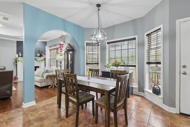 dining area featuring tile patterned flooring, visible vents, a chandelier, and baseboards