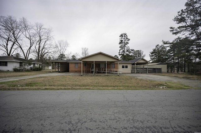 view of front of property featuring an attached carport, a porch, brick siding, and driveway