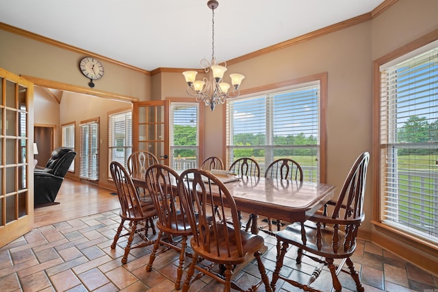 dining room featuring stone tile floors, a chandelier, and crown molding