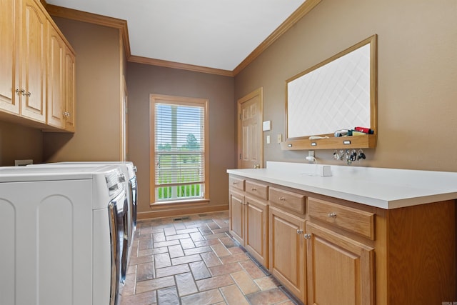 laundry room featuring crown molding, washing machine and dryer, cabinet space, and baseboards