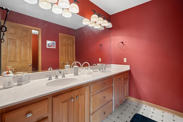 full bathroom featuring an inviting chandelier, double vanity, baseboards, and a sink