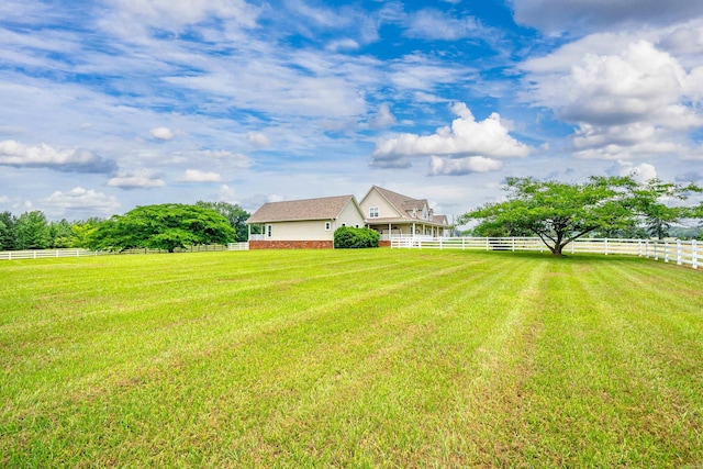 view of yard with a rural view and fence