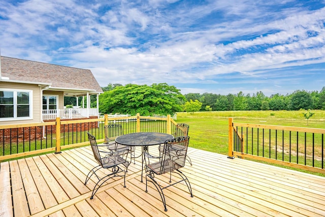 wooden terrace with a yard and outdoor dining space