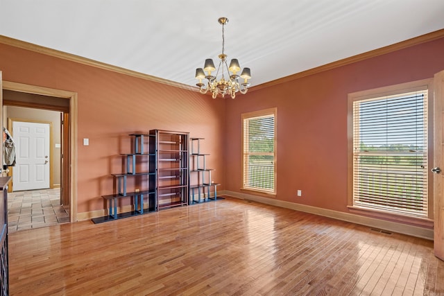 unfurnished room with a notable chandelier, baseboards, light wood-style floors, and crown molding