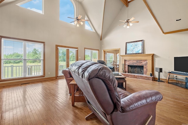 living area featuring hardwood / wood-style floors, a ceiling fan, baseboards, visible vents, and a fireplace