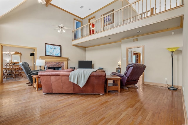 living area with ornamental molding, a fireplace, baseboards, and hardwood / wood-style flooring