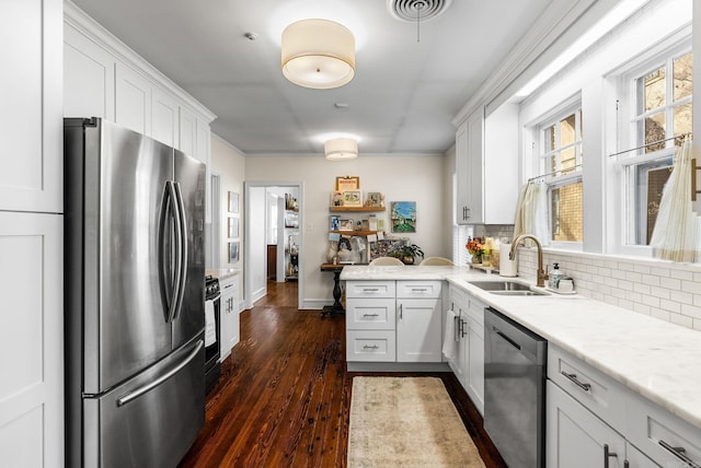 kitchen with visible vents, dark wood-style flooring, a sink, decorative backsplash, and stainless steel appliances