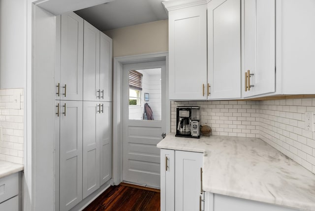 kitchen featuring dark wood finished floors, decorative backsplash, white cabinets, and light stone countertops