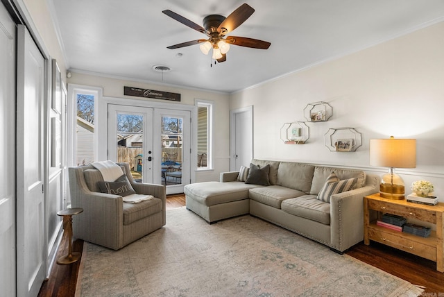 living room featuring wood finished floors, crown molding, french doors, and visible vents