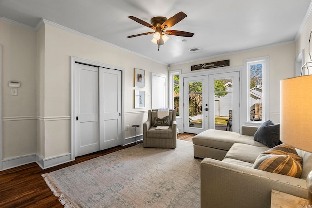 living area featuring wood finished floors, baseboards, visible vents, ornamental molding, and french doors