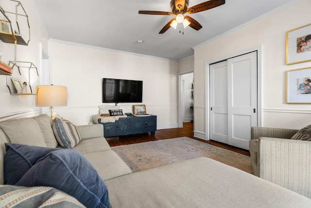 living room featuring baseboards, a ceiling fan, wood finished floors, and crown molding