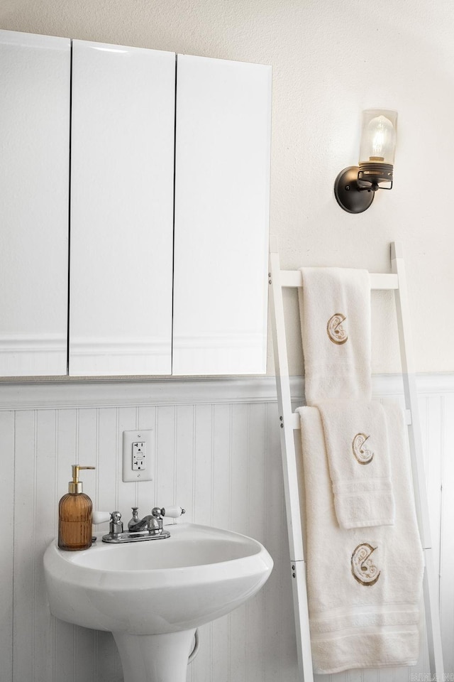 bathroom featuring a sink and a wainscoted wall