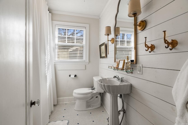 full bath featuring plenty of natural light, wood walls, toilet, and ornamental molding