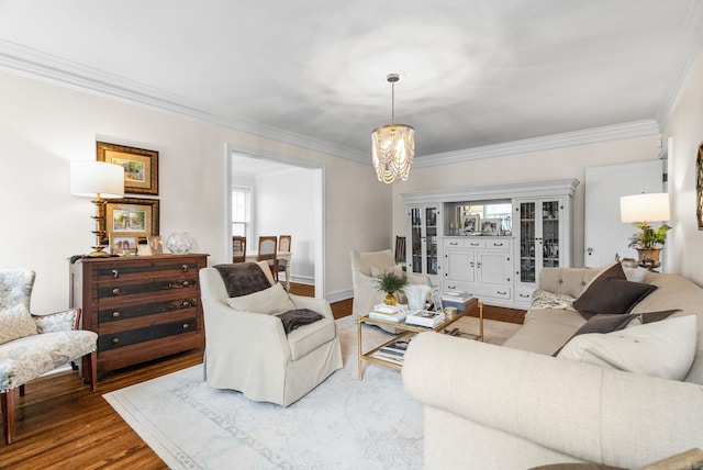 living room with crown molding, a notable chandelier, and wood finished floors