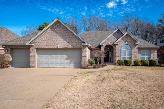 ranch-style house featuring a front yard, an attached garage, brick siding, and driveway