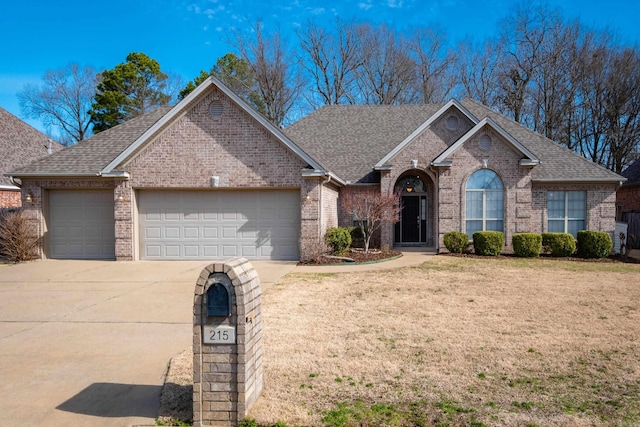 ranch-style house featuring concrete driveway, brick siding, a garage, and a front lawn