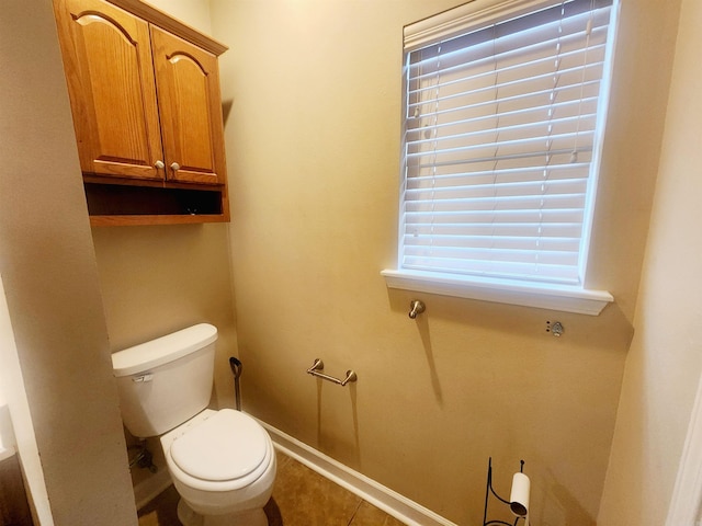 bathroom with tile patterned flooring, toilet, and baseboards