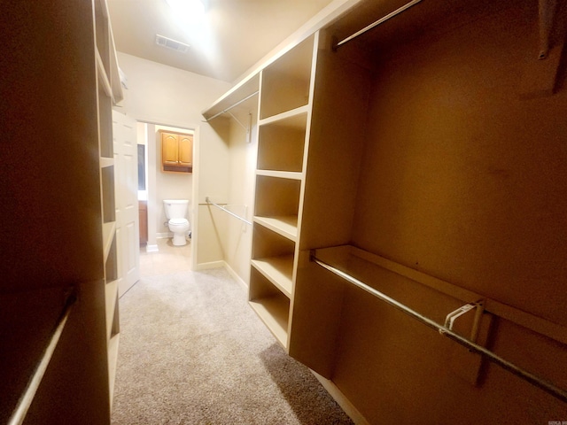 walk in closet with visible vents and light carpet