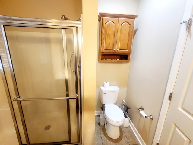 full bath featuring baseboards, toilet, a shower stall, and tile patterned flooring