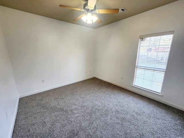 unfurnished room with a ceiling fan, visible vents, carpet, and baseboards