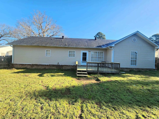 back of property featuring a yard, a deck, and fence