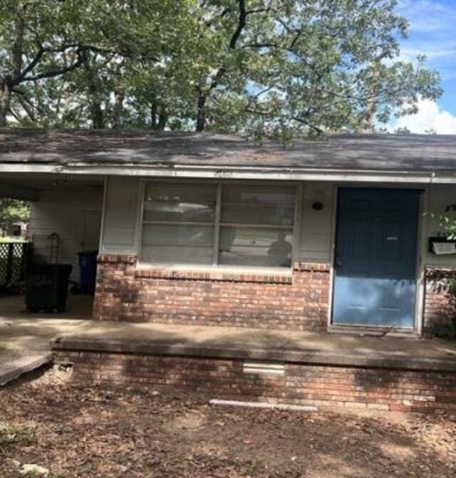 view of exterior entry featuring brick siding