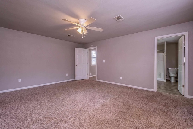 carpeted spare room with visible vents, baseboards, and a ceiling fan