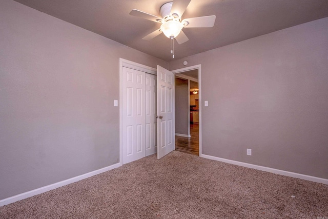 unfurnished bedroom with carpet flooring, a ceiling fan, baseboards, and a closet