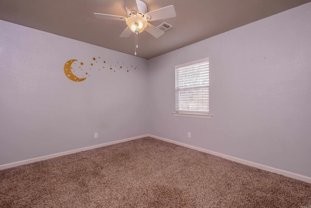 carpeted spare room with visible vents, baseboards, and a ceiling fan