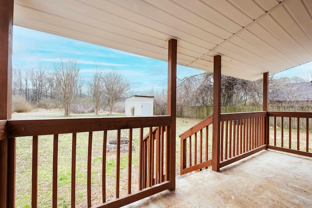 wooden deck featuring an outbuilding, a porch, and a shed