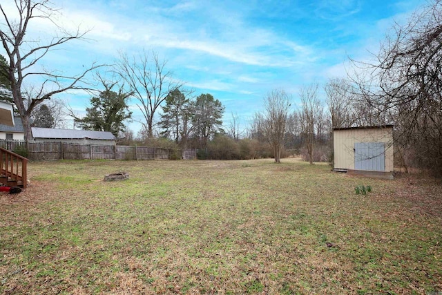 view of yard with a storage shed, an outdoor structure, and fence