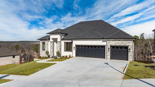 french country inspired facade featuring driveway, stone siding, roof with shingles, a front yard, and a garage